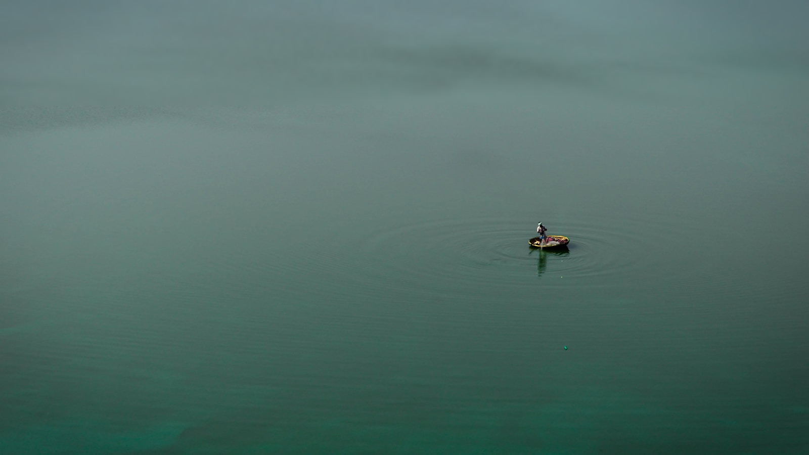 person in black shirt riding on boat on body of water during daytime
