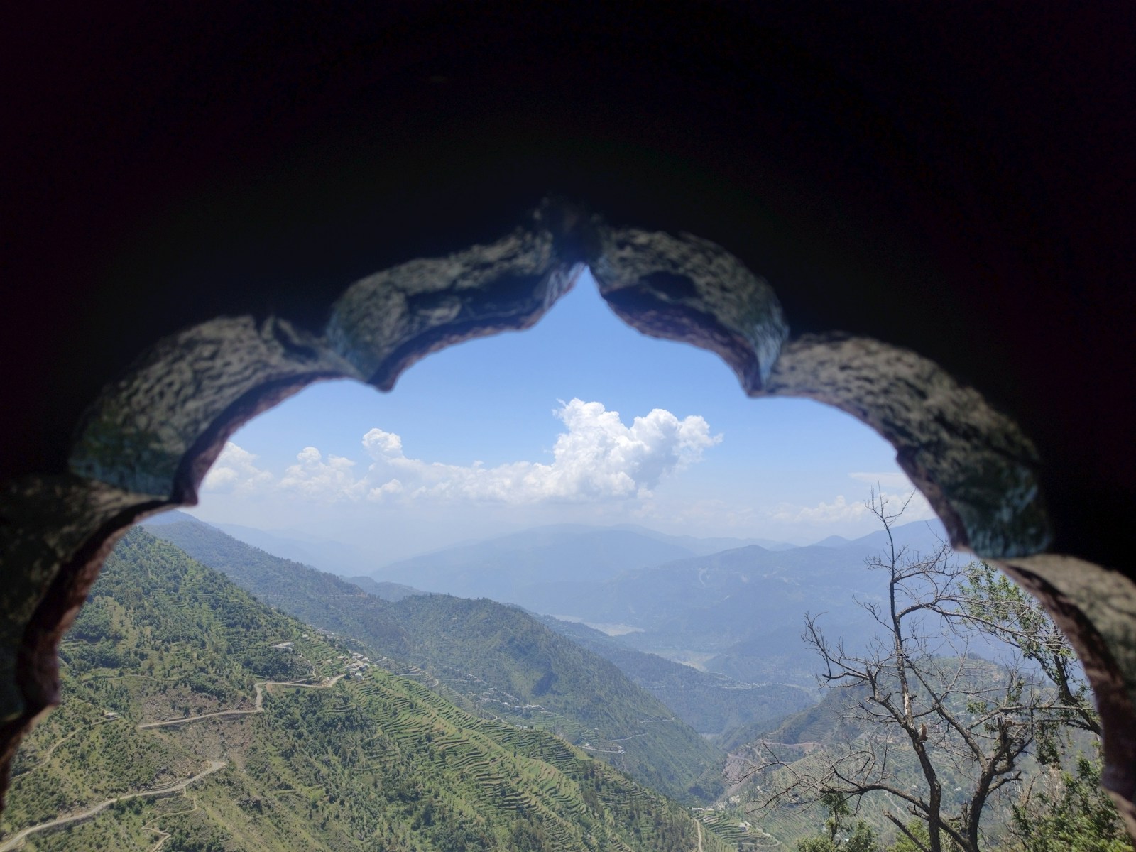 A view of a valley through a hole in a rock