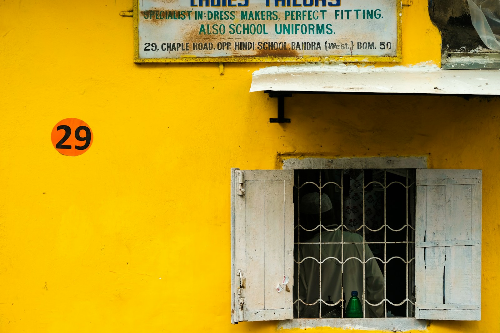 a yellow building with a sign on the side of it
