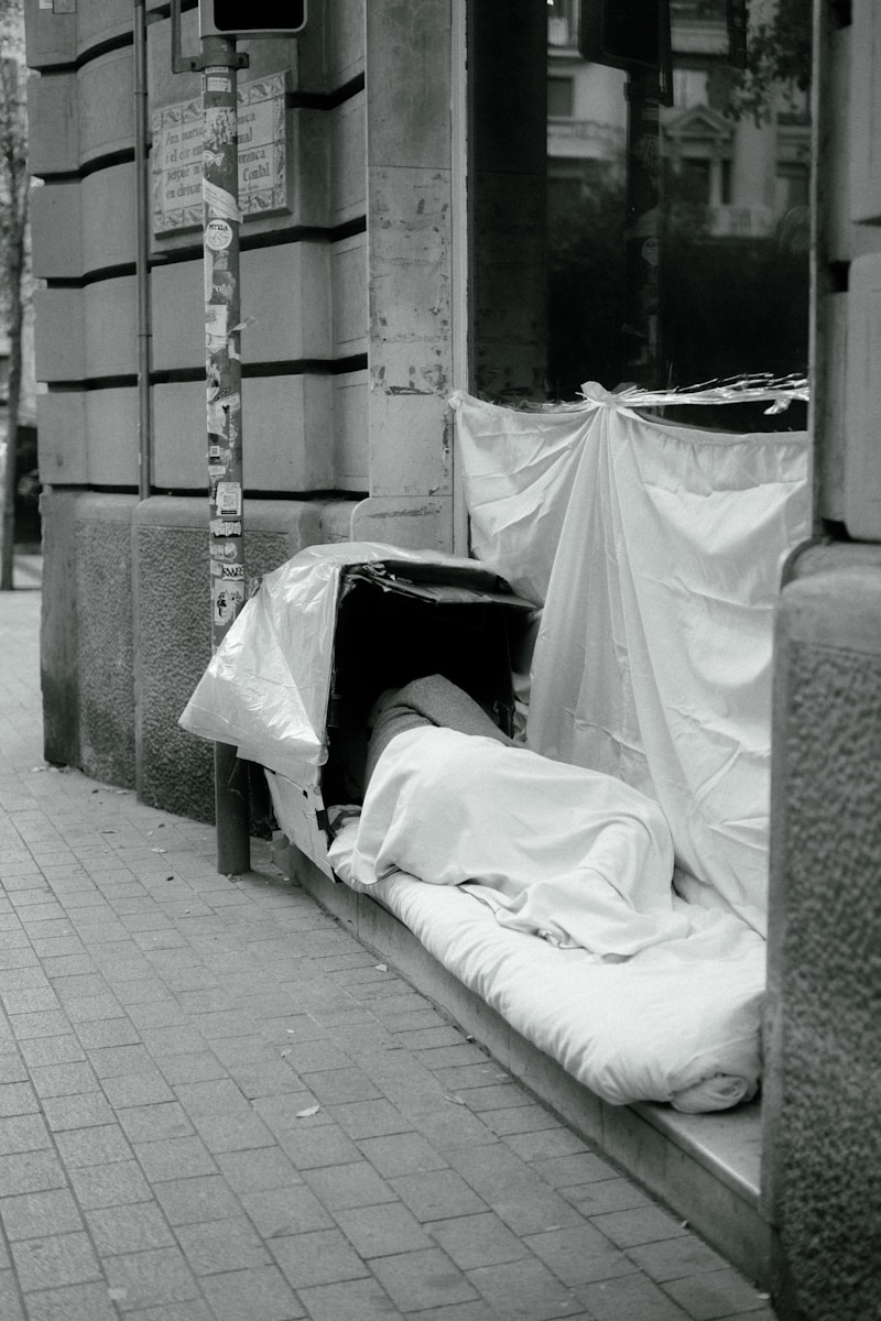 a black and white photo of a mattress on the sidewalk